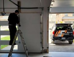 Technician repairing a garage door at night, illustrating 24/7 emergency garage door repair services in 2025
