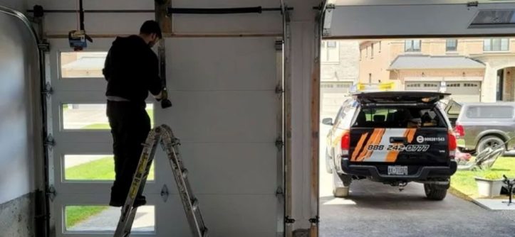 Technician repairing a garage door at night, illustrating 24/7 emergency garage door repair services in 2025