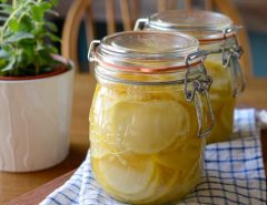 Alt Text 1: A clear glass jar of homemade allulose syrup sits on a clean kitchen counter next to a bag of granulated allulose