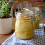 Alt Text 1: A clear glass jar of homemade allulose syrup sits on a clean kitchen counter next to a bag of granulated allulose