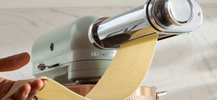 KitchenAid mixer rolling fresh pasta dough into thin golden sheets