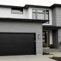 Contemporary home featuring sleek black flat-panel garage door with matching black trim and gray horizontal siding