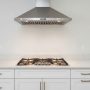 Modern stainless steel 30-inch range hood mounted above gas cooktop in contemporary kitchen with white cabinets