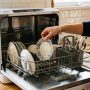 Sleek countertop dishwasher operating in a modern kitchen.