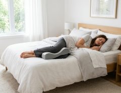 Side sleeper using an ergonomic knee pillow for spinal alignment.