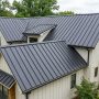 Stack of formed metal roof panels with raised seams on a job site
