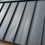 Striated metal roof panel showing shallow grooves along the pan