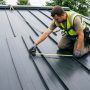 Tape measure held against a raised seam on a metal roof panel