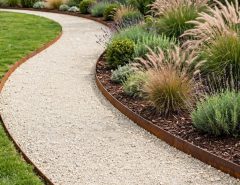 Contemporary garden pathway edged with narrow Corten steel strips containing pale decorative gravel