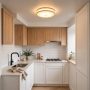 Flush mount ceiling light glowing in a small kitchen with low ceilings