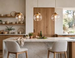 Three pendant lights hanging over a kitchen island above a marble countertop