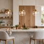 Three pendant lights hanging over a kitchen island above a marble countertop